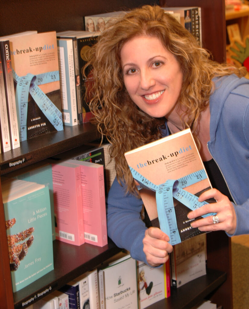 Annette Fix holding a copy of her book The Break-Up Diet: A Memoir in a Barnes & Noble store